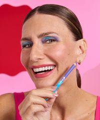 modelo usando o lapis delineador nos olhos misturando as cores roxa e azul modelo usando o lapis delineador nos olhos misturando as cores roxa e azul